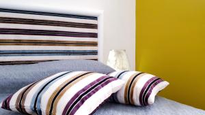 a bedroom with a bed with a headboard and two pillows at Mediterraneo House in Palermo