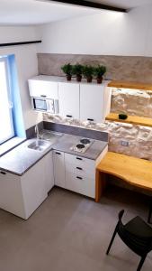 a small kitchen with white cabinets and a sink at Mediterraneo House in Palermo