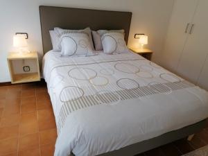 a bedroom with a large white bed with two lamps at Apartaments Bonaventura 7 in Sitges