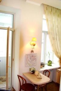 une petite table et des chaises dans une cuisine avec une fenêtre dans l'établissement Alex Apartments on Puskinskaya-Chikalenko new name, à Kiev 17 autres photos