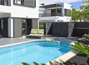 a swimming pool in front of a house at Sea views modern villa for relaxing holidays in Costa Teguise