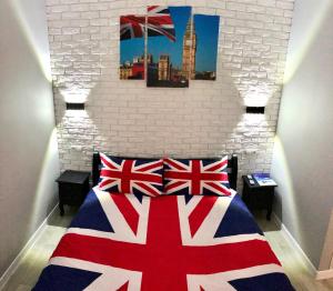 - une chambre avec un lit arborant des drapeaux friables dans l'établissement Apartment Studio LONDON 92, à Irpin