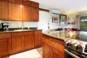 a kitchen with wooden cabinets and a counter top at Kihei Kai Oceanfront Condos in Kihei