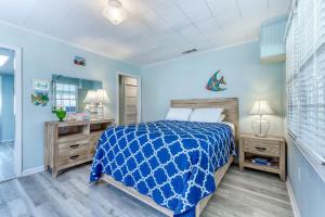a blue bedroom with a bed and a mirror at Beach Cottage on Jones in Tybee Island