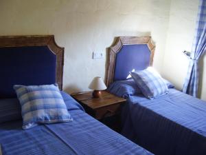 sypialnia z 2 łóżkami i stołem z lampką w obiekcie Casa Isabel by CasaTuristica w mieście Parauta