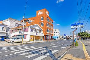 an empty city street with a building and a crosswalk at 47HOSTEL in Wadomari
