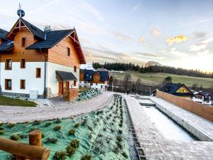 a house with a pool of water next to a building at Ostoja Bukowinki - Peniński Las in Jaworki