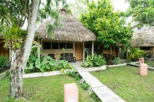 蒂卡尔Hotel Tikal Inn的茅草屋顶和院子的房子