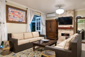 a living room with two couches and a fireplace at Edgewater Beach Villa - Beach Front, Close to All Attractions in St Mary