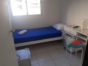 a small bedroom with a blue bed and a desk at Cañitas Home in Buenos Aires