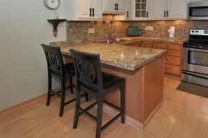 a kitchen with a counter and two chairs at a kitchen island at Kihei Kai Oceanfront Condos in Kihei