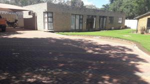 a brick driveway leading to a brick house at NEW LODGE - Universitas in Bloemfontein