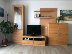 a living room with a tv on a wooden entertainment center at Steiner Strandappartements Appartement 304 Seeseite in Stein