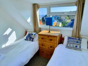 two twin beds in a room with a window at Summerhill Apartments in Shanklin