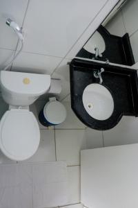 a bathroom with a toilet and a sink at POUSADA TEIXEIRA in Barreirinhas