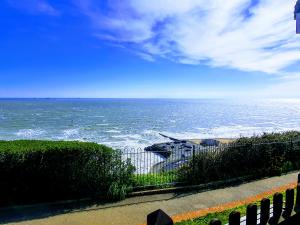 una vista del océano desde detrás de una valla en Summerhill Apartments en Shanklin