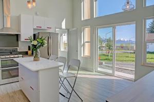 a kitchen with white cabinets and a counter with chairs at The Vue B&B in Seward