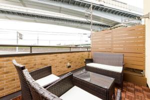 a balcony with two chairs and a brick wall at QIQA Residence in Tokyo