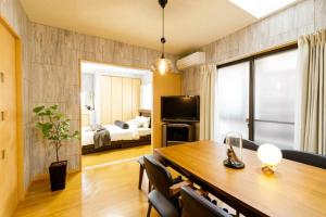 a room with a dining table and a bedroom at QIQA Residence in Tokyo