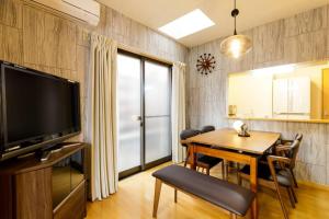 a dining room with a table and a television at QIQA Residence in Tokyo