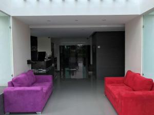 uma sala de estar com sofás roxos e vermelhos em Best Western Plus Metepec & Suites em Toluca
