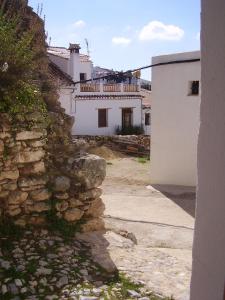 eine Steinmauer neben einem weißen Gebäude in der Unterkunft Casa El Menúo in Parauta
