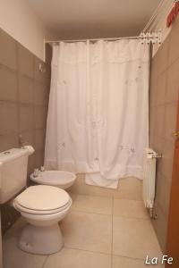 a bathroom with a toilet and a shower curtain at Departamentos La fe in Ushuaia