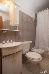 une salle de bain avec toilettes, lavabo et douche dans l'établissement Departamentos La fe, à Ushuaia 49 autres photos