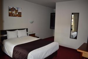 a hotel room with a bed and a mirror at Colonial Plaza Hotel in Puno