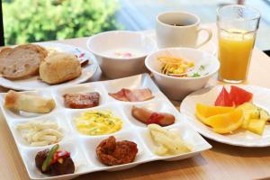 a tray of breakfast foods and a cup of orange juice at Smile Hotel Premium Osaka Higashishinsaibashi in Osaka
