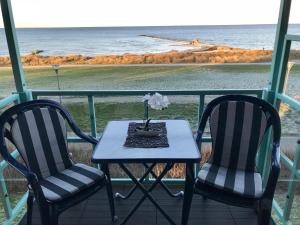 a table and two chairs on a balcony with the ocean at Steiner Strandappartements Appartement 304 Seeseite in Stein
