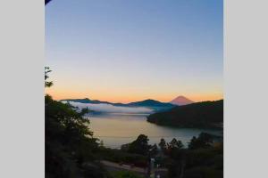 Blick auf einen Wasserkörper bei Sonnenuntergang in der Unterkunft Chalet Itomic M in Hakone