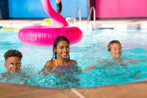 3 enfants jouant dans une piscine dans l'établissement Cartoon Network Hotel, à Lancaster