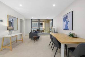 a living room with a table and a dining room at YARRA · YARRA Toorak Rd & Chapel St. Pool, Gym & Parking in Melbourne
