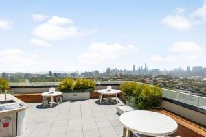 d'un balcon avec des tables et une vue sur la ville. dans l'établissement YARRA · YARRA Toorak Rd & Chapel St. Pool, Gym & Parking, à Melbourne