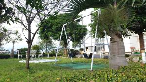 a swing set in a park with a palm tree at Beauty Monroe B&B-可包棟-150吋投影-唱歌-夏日玩水-烤肉-電動麻將 in Wujie