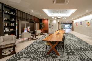 a lobby with a long wooden table and chairs at Hotel Gran Ms Kyoto in Kyoto