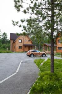 a car parked in a parking lot in front of a house at Ski-Let Hotel in Baykalsk