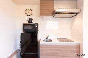 a small kitchen with a sink and a microwave at VILLA HAKONE STAGE in Hakone