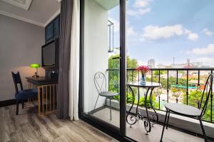 Cette chambre dispose d'un balcon avec une table et des chaises. dans l'établissement Solaria Hanoi Hotel, à Hanoï