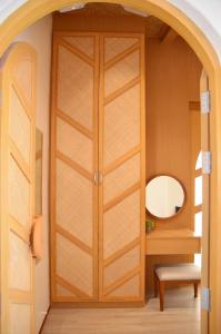 una puerta de madera en una habitación con espejo en Pannana Cha-am, en Cha Am