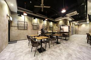 um restaurante com mesas e cadeiras num quarto em Masan Almond Hotel em Changwon