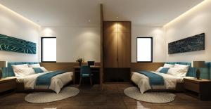 a bedroom with two beds and a desk at Trang Ngan Hotel by THG in Danang