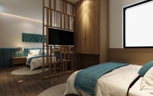 a bedroom with a bed and a flat screen tv at Trang Ngan Hotel by THG in Danang