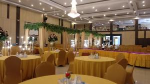 un salón de banquetes con mesas y sillas amarillas en Comforta Dumai, en Dumai