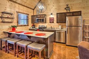 a kitchen with a large island with bar stools at The Breeze Forested Oasis with Hot Tub and Deck! in Broken Bow