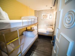 a small room with two bunk beds and a bathroom at King Wow Inn in Tainan