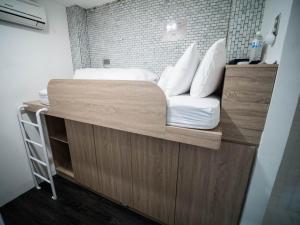 a bed with white sheets and pillows on it at King Wow Inn in Tainan