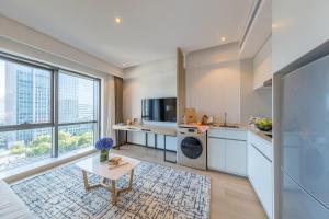 a kitchen with white cabinets and a table at Sincere Residence Changfeng - Changfeng Ecological Business District in Shanghai