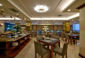 a dining room with tables and chairs in a restaurant at Aquari Hotel in Ho Chi Minh City